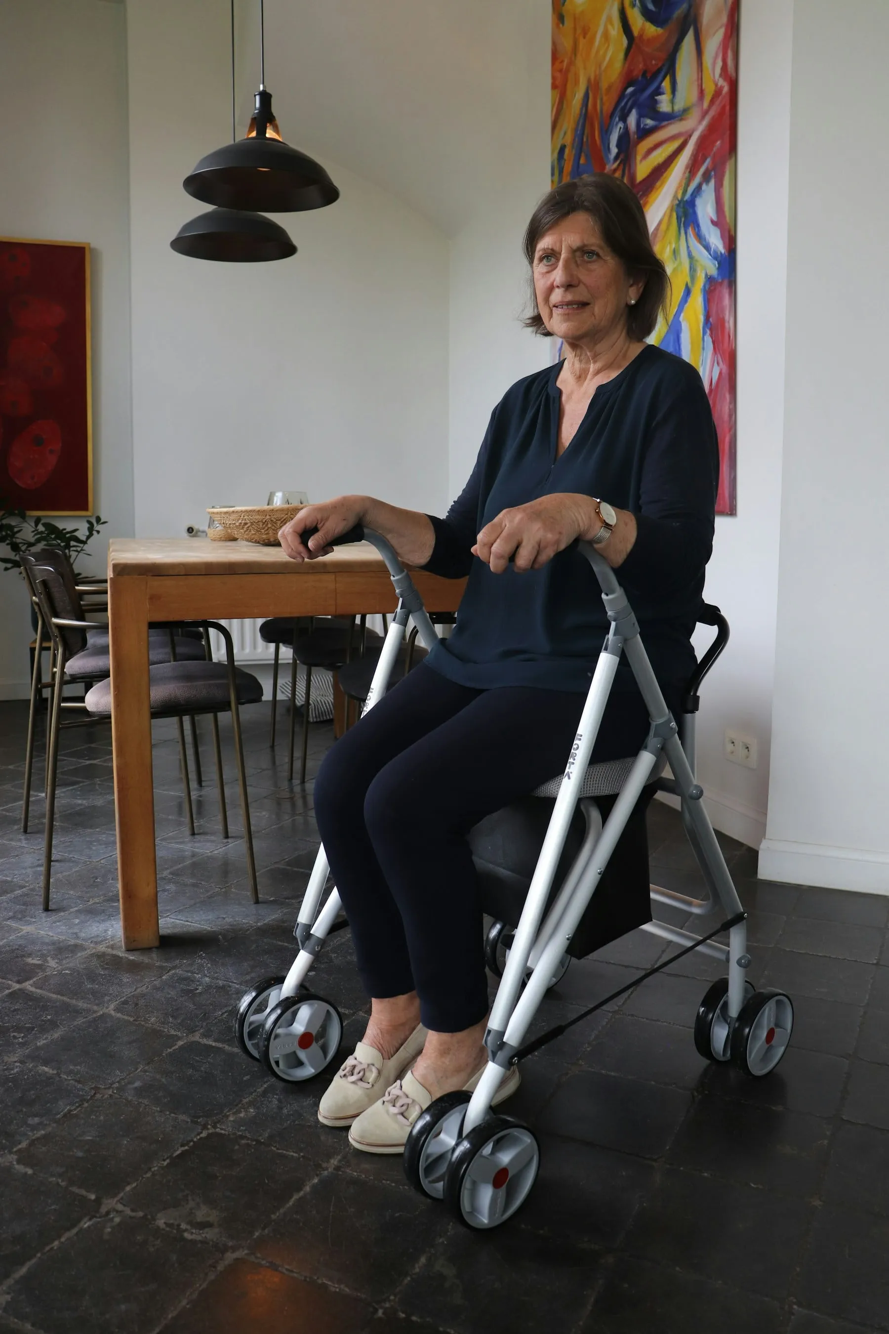 Starsza kobieta siedząca na balkoniku z siedziskiem w jasnym wnętrzu